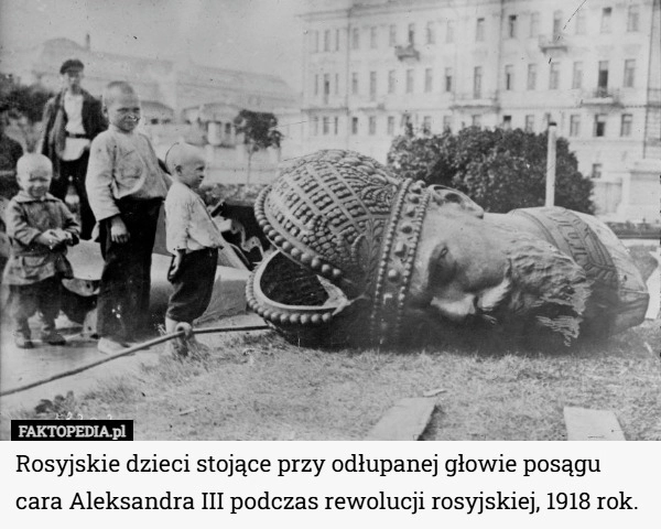 
    Rosyjskie dzieci stojące przy odłupanej głowie posągu cara Aleksandra III...